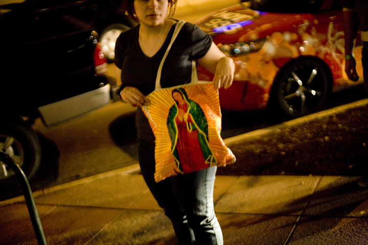 A young girl shows off the bag her mother made and decorated with the image of la Virgen de Guadalupe in Austin, Texas.