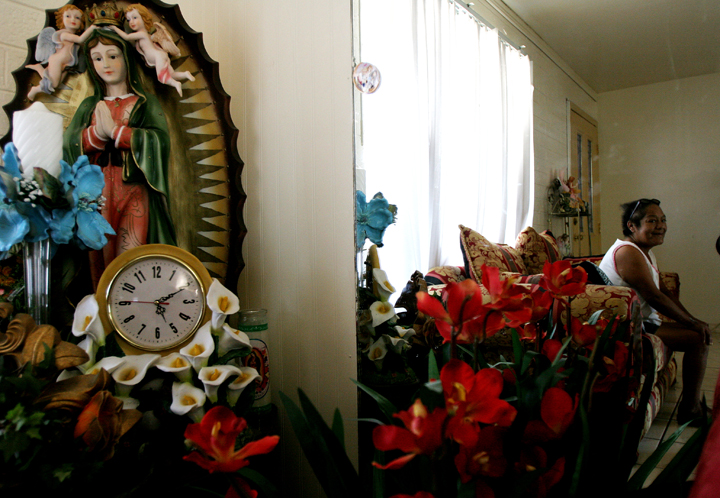 A diabetic patient sits in her living room, watched over by a Virgen de Guadalupe in Phoenix, Ariz.